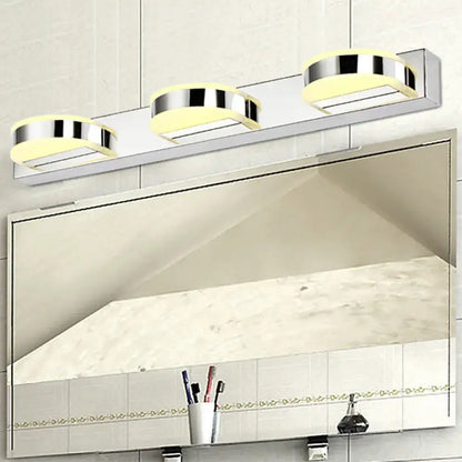 Modern chrome and black geometric wall light with three softly glowing yellow led bulbs in nickel finish for bathroom use