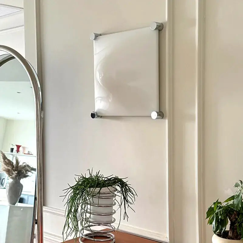 White rectangular magnetic board with silver metallic frame and knobs complementing decorbites bolla wall sconces light