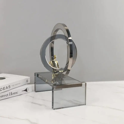 Modern chrome and golden rings golden man sculpture with interlocking geometric crystal rings on acrylic base for living room decor