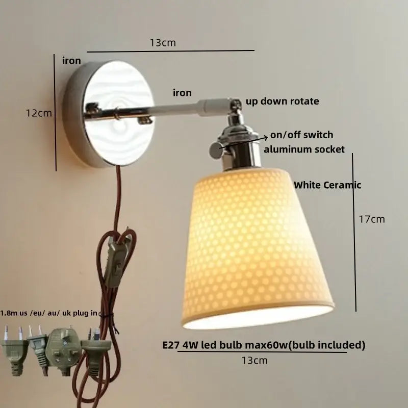 A modern chrome wall light fixture with a polished iron adjustable arm and white ceramic dotted shade for bedrooms