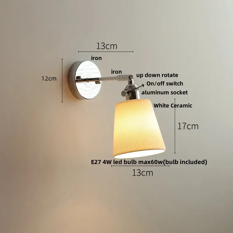 A sleek modern wall light fixture with polished iron arm and white ceramic ridged shade for bedroom lighting