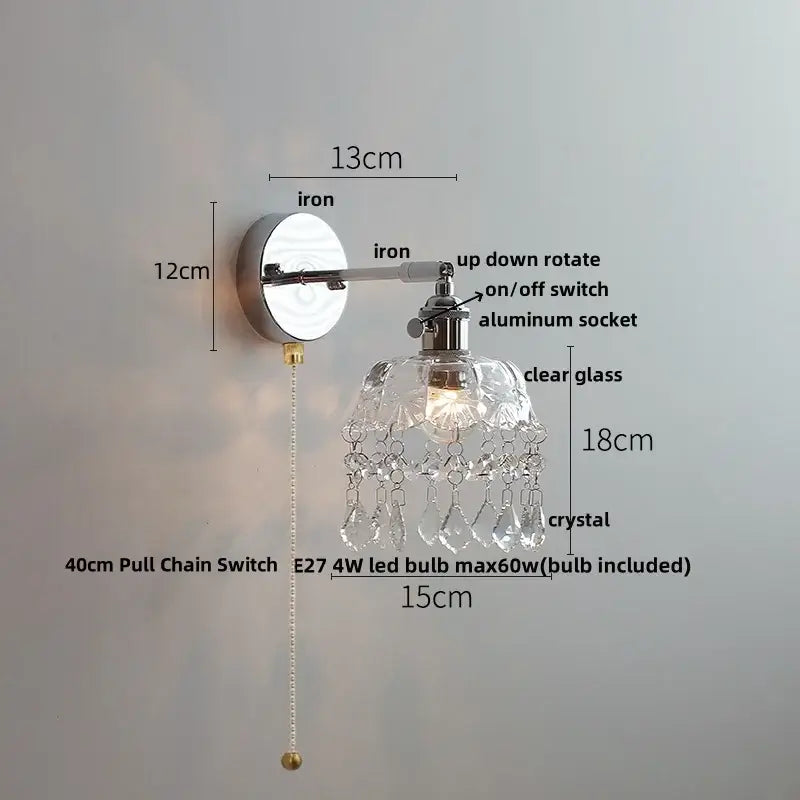 Modern chrome wall light fixture with polished iron arm, clear glass shade, and faceted crystal droplets for bedroom use