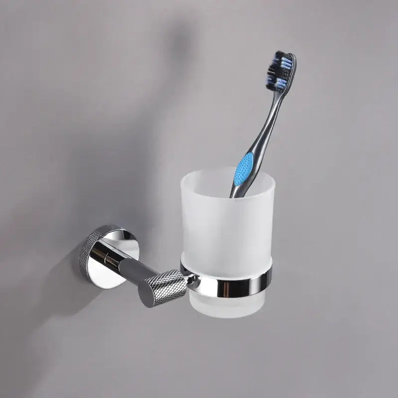 Modern chrome bathroom essentials set featuring a chrome wall-mounted toothbrush holder with frosted glass cup and black blue toothbrush decorbites bathroom essentials