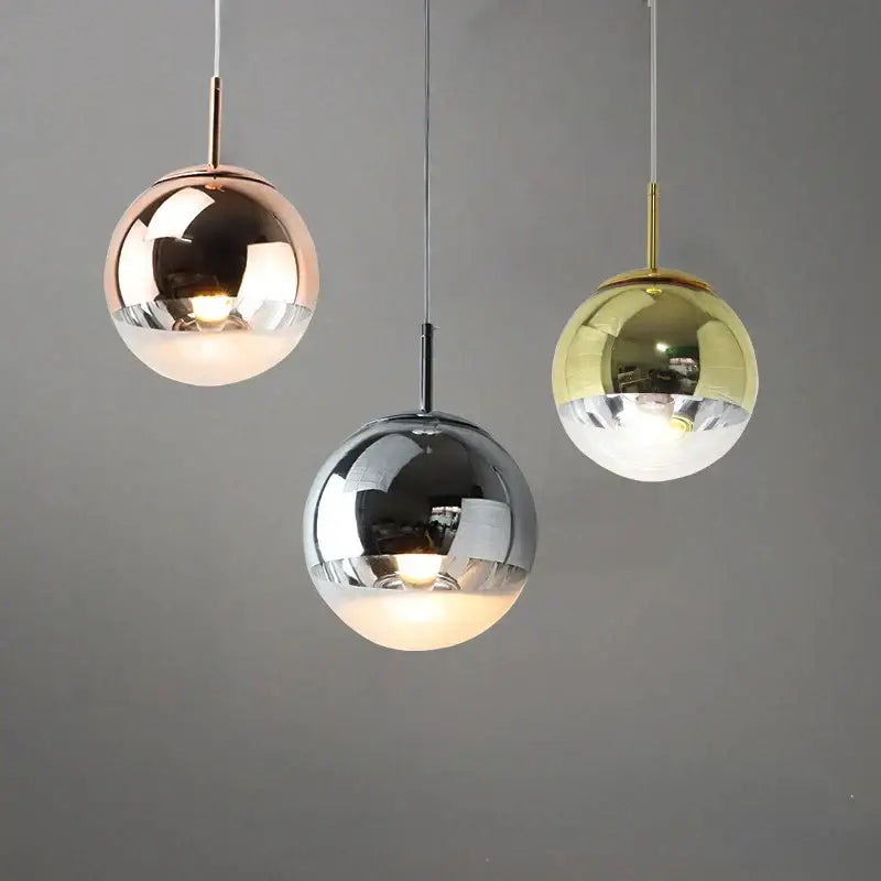 Three spherical glass ball led pendant lights in rose gold, chrome, and brass for modern dining rooms