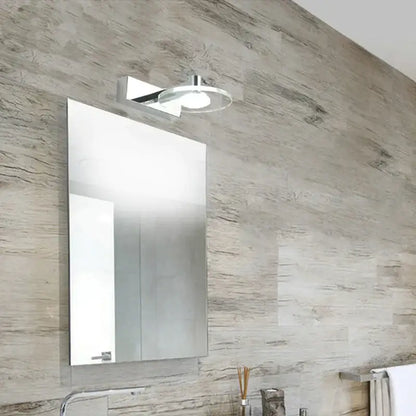 Modern chrome crystal led wall lamp above a silver metallic decorbites acrylic mirror medicine cabinet on textured stone wall