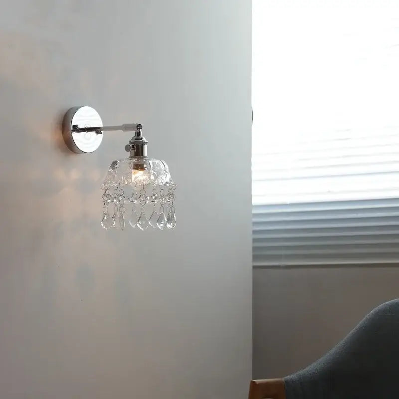 Modern chrome crystal led wall light featuring a delicate chandelier-style sconce with teardrop crystals by decorbites