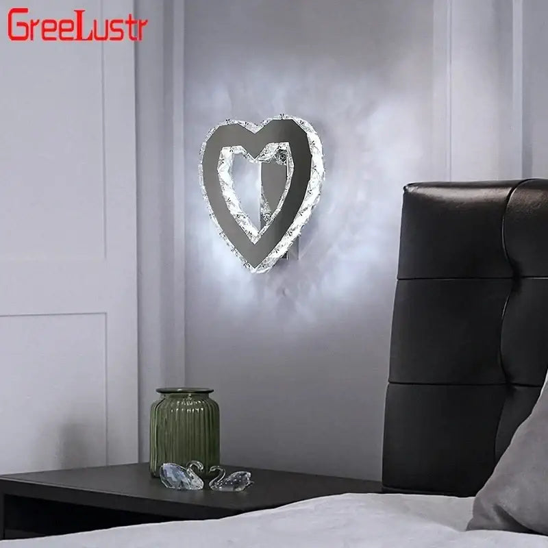 A modern chrome crystal led wall sconce with a heart-shaped silver metallic frame for living room decorbites crystal led
