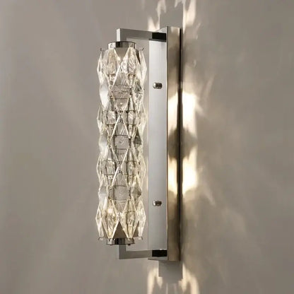 Modern chrome crystal wall lamp with sleek frame and faceted crystal cylinder for luxury bedroom lighting decorbites crystal wall