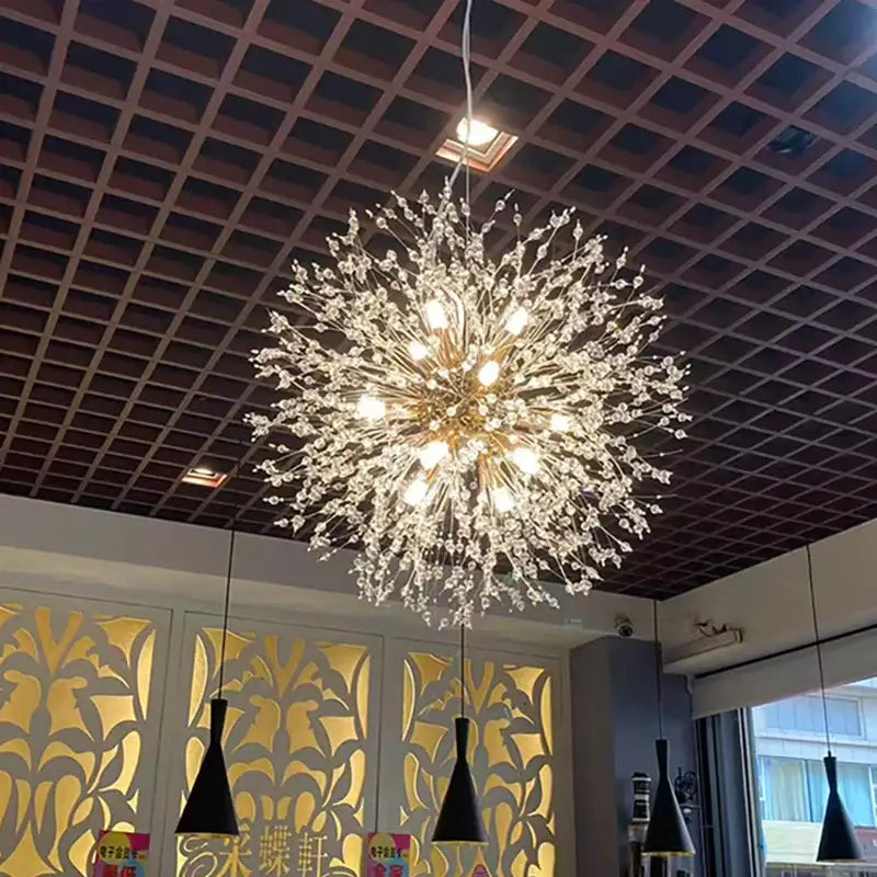 A modern chrome pendant light with clear acrylic beads in a radial flower design for bedroom lighting