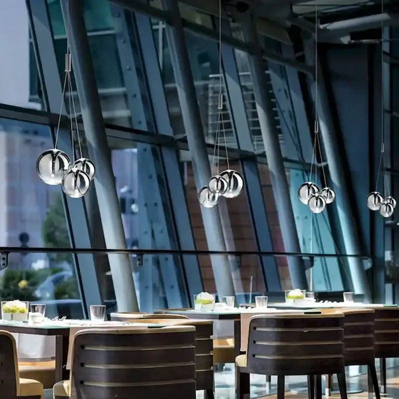 Modern chrome decorbites glass ball pendant light is a spherical chrome-finished light fixture for living rooms