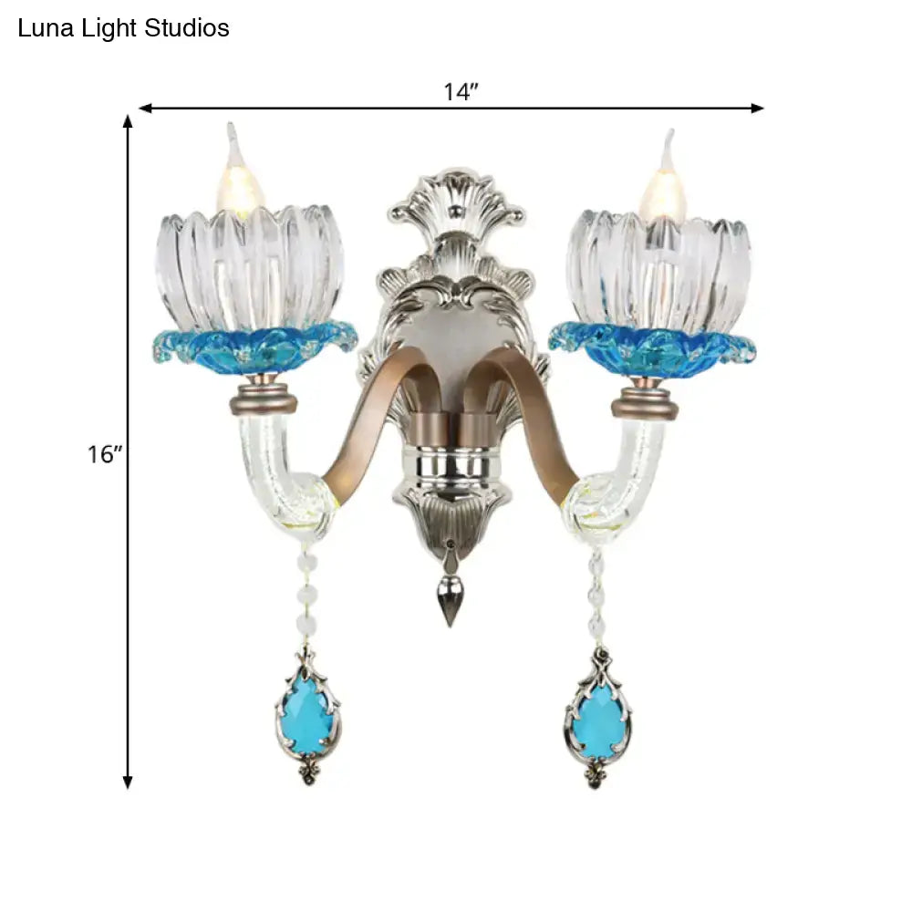 Elegant modern two-light wall light with chrome finish, clear glass, and turquoise accents for bedroom use