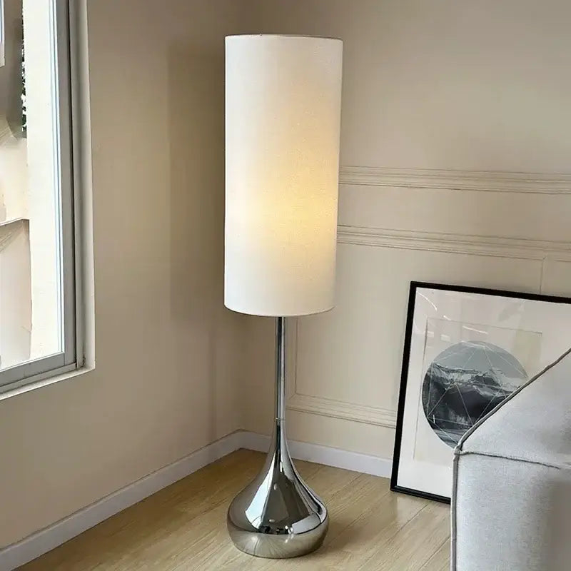 Modern chrome floor lamp with a tall cylindrical cream fabric shade for stylish living room decorbites cream fabric