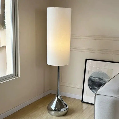 Modern chrome floor lamp with a tall cylindrical cream fabric shade for stylish living room decorbites cream fabric