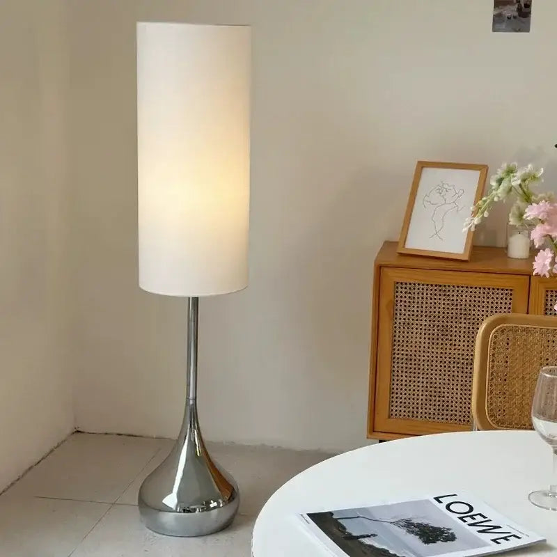 A sleek modern floor lamp with a white fabric shade and polished chrome base perfect for decorbites cream fabric decor