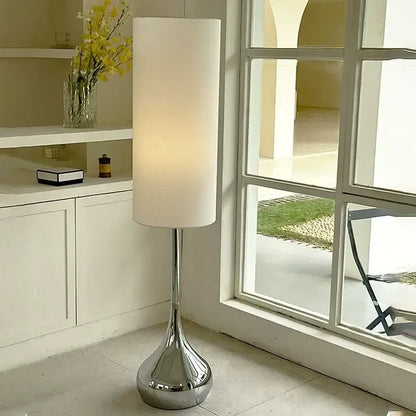 A modern floor lamp with a tall cream fabric shade and polished chrome base ideal for living room decorbites cream fabric