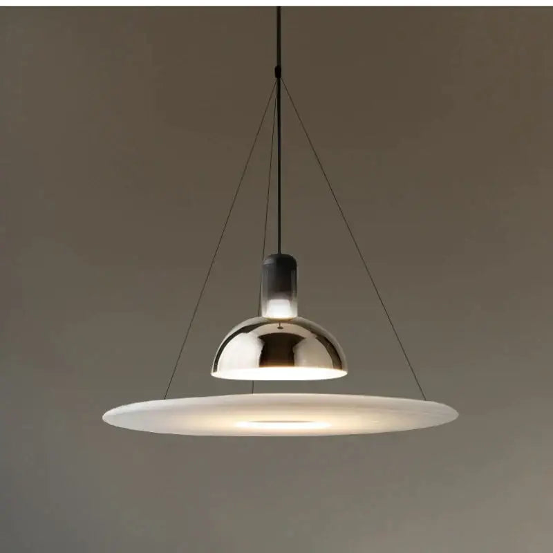 Modern chrome flying saucer chandelier with polished chrome dome and frosted glass disc suspended by black cords for living room lighting