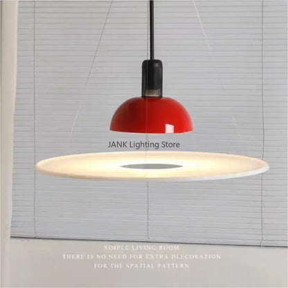 A sleek modern chrome flying saucer chandelier with a glossy red dome and white base for living room lighting