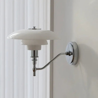 A sleek modern chrome french glass wall lamp with a glossy white ceramic shade and polished metal arm for bedroom decor
