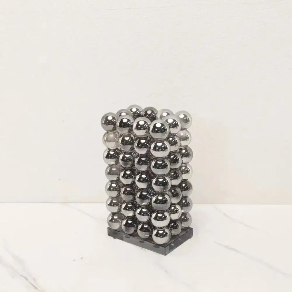 A sleek rectangular tower made of polished silver magnetic balls for modern chrome geometric crystal ball decor
