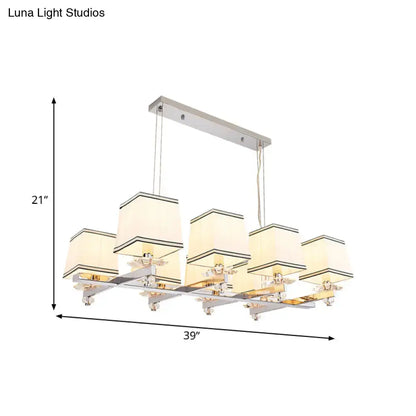 Modern chrome island pendant light with five cream fabric shades and black trim in a sleek chrome frame for dining rooms
