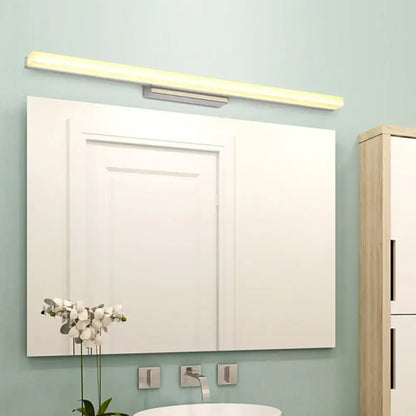 Modern chrome led wall light with streamlined metal shade above rectangular bathroom mirror with integrated led light