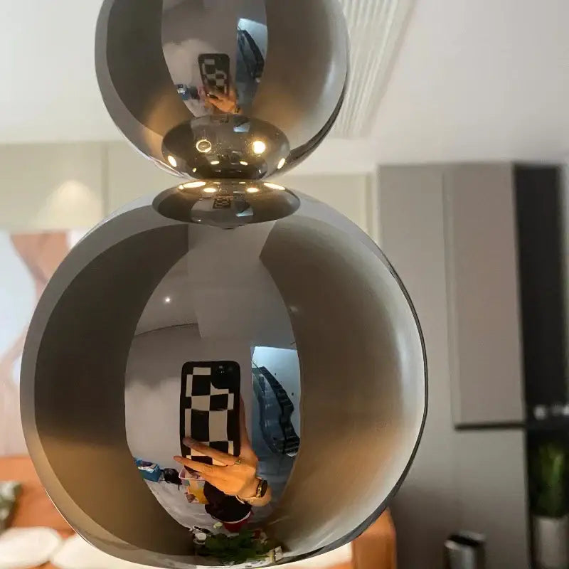 Modern chrome multi ball pendant light source featuring shiny chrome spherical double orb design for bedroom use