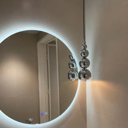 A modern chrome multi ball pendant light with stacked spherical bulbs hanging from a black cord light source