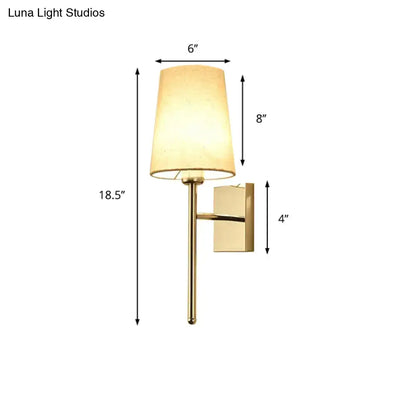 Gold-finished tapered wall sconce with a warm beige fabric shade ideal for modern bedroom fabric led light lighting