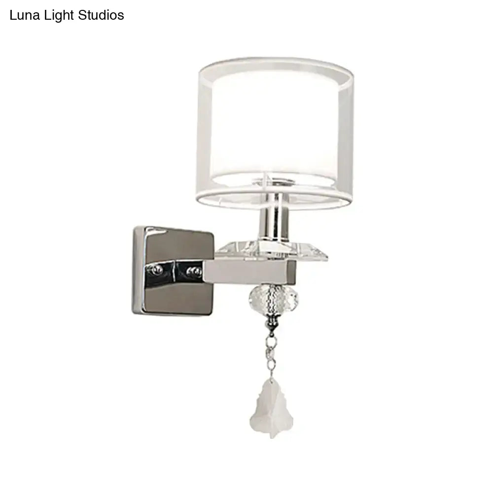 Modern chrome wall lamp featuring double glass cylinder shade with crystal accent suitable for bedroom lighting