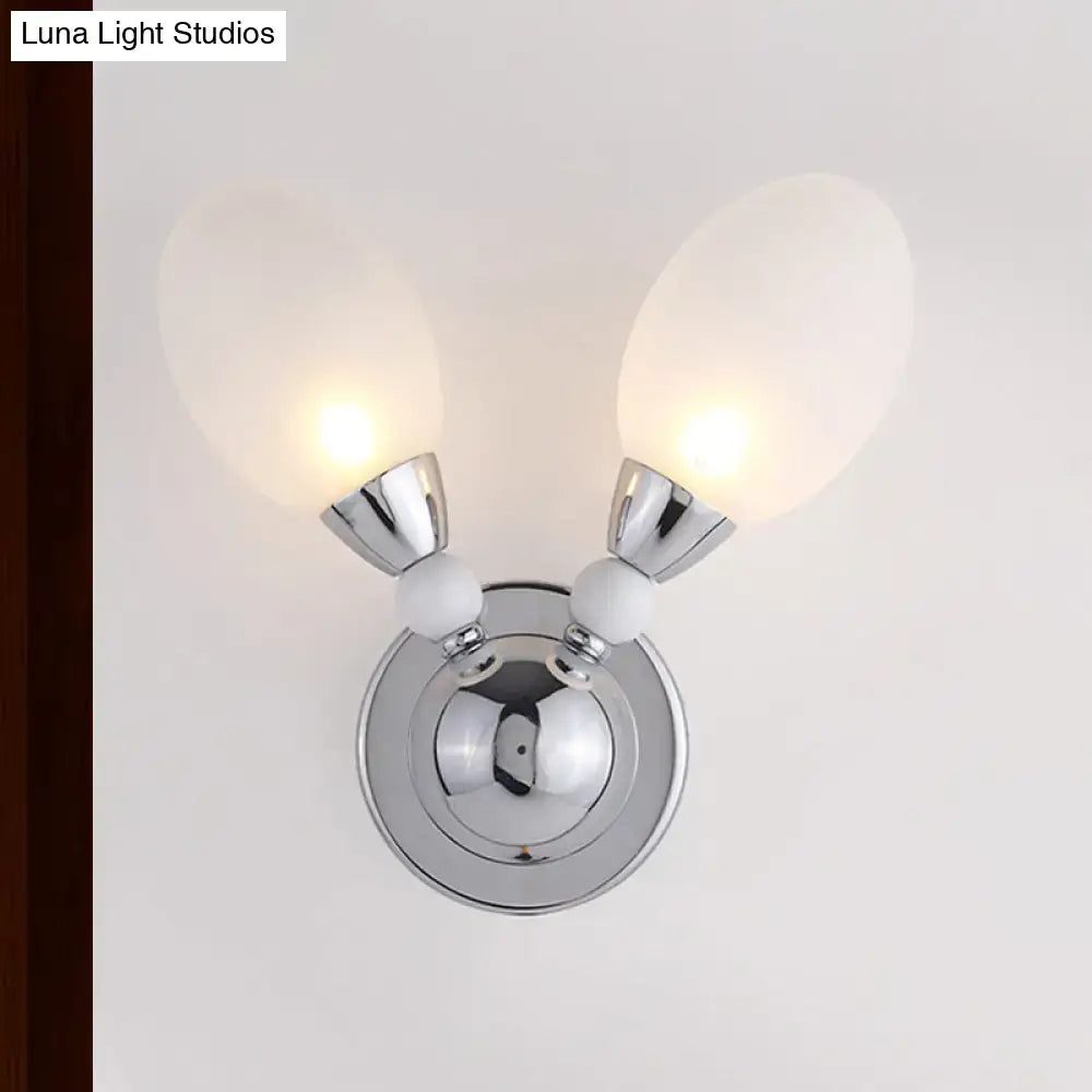 Modern chrome wall light with two frosted white glass globes and white ceramic accents for bedroom sconce lighting