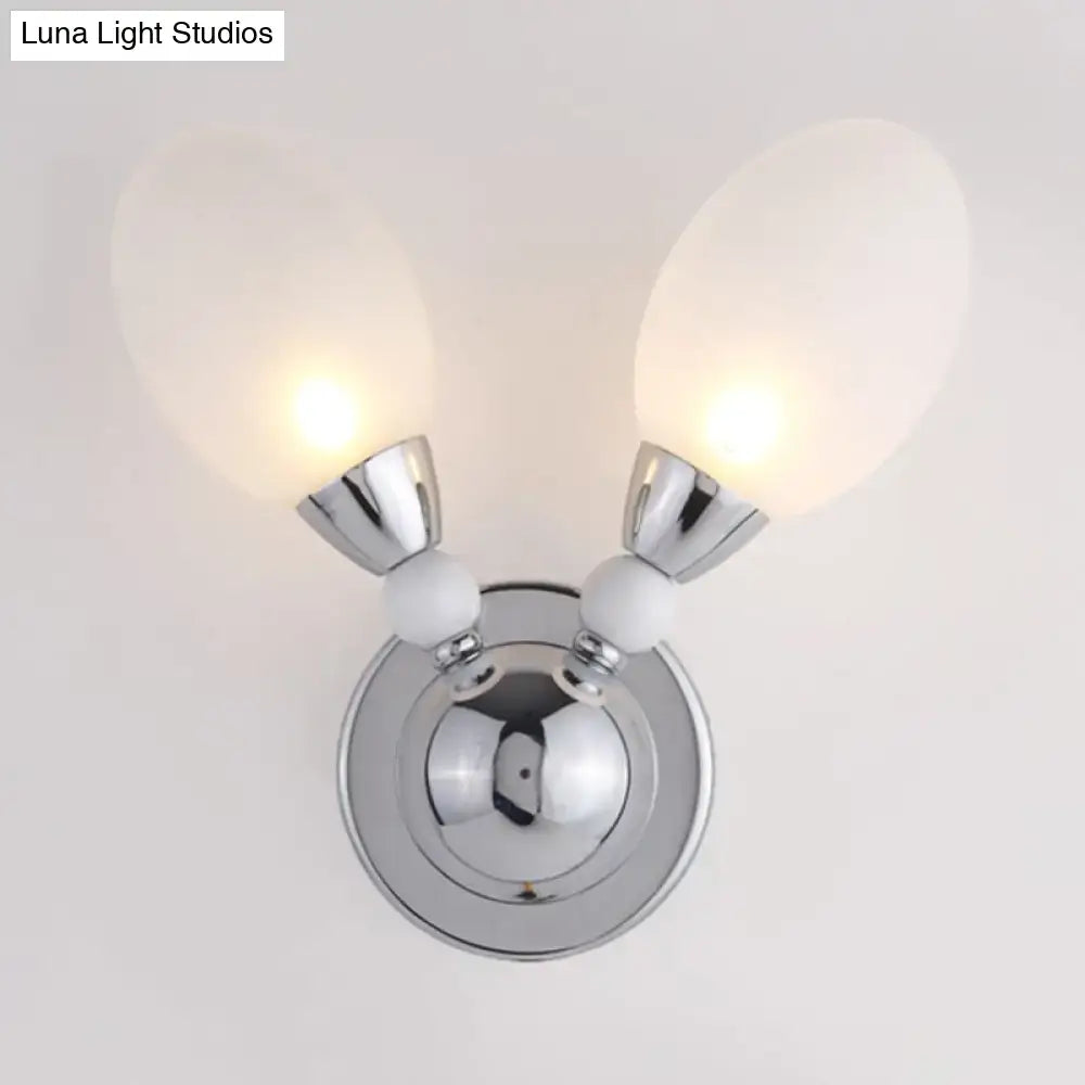 Modern chrome wall light with double white glass shades and decorative spheres designed as a bedroom sconce