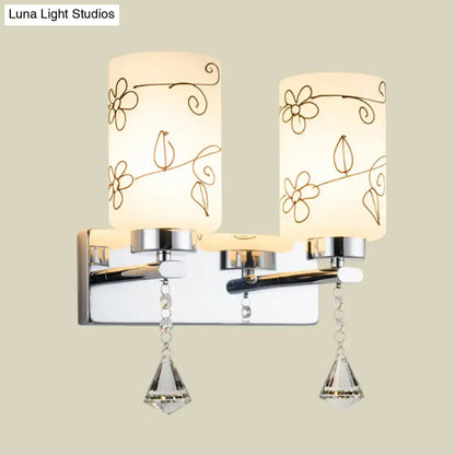 Modern chrome white glass cylinder wall sconce with two frosted white glass shades and crystal pendants for bedroom lighting