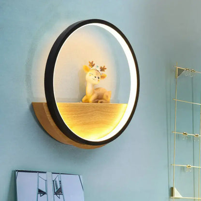 Modern circular black wall light with warm led glow and wooden shelf featuring a decorative deer figurine for living room