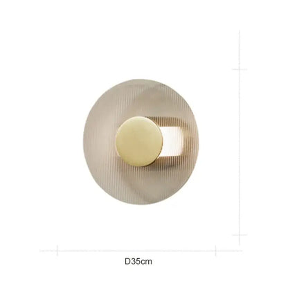 Modern circular brushed gold wall lamp with concentric ridged texture and central light source for elegant glass decorbites wall