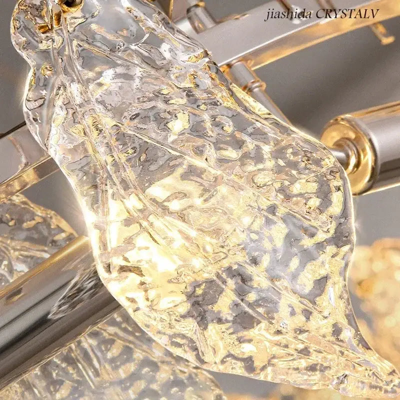 Modern circular glass petal led chandelier featuring a clear textured glass leaf pendant with gold accents and metallic frame