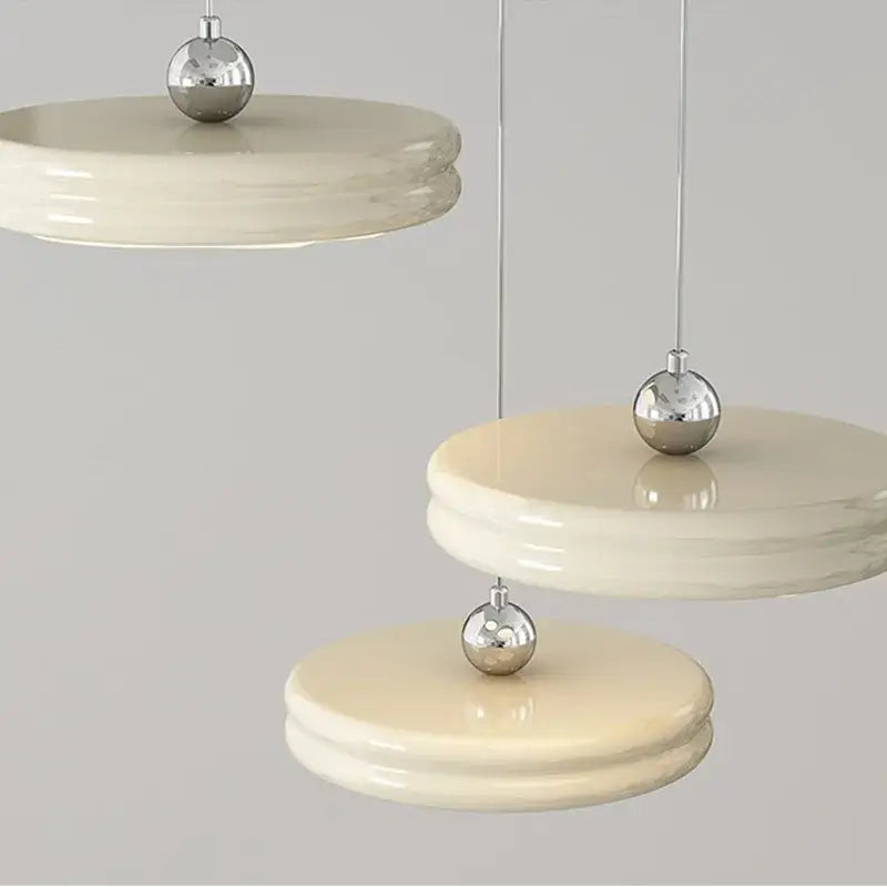 Cream-colored layered circular modern chandelier with polished silver accents for dining room decorbites circular modern design