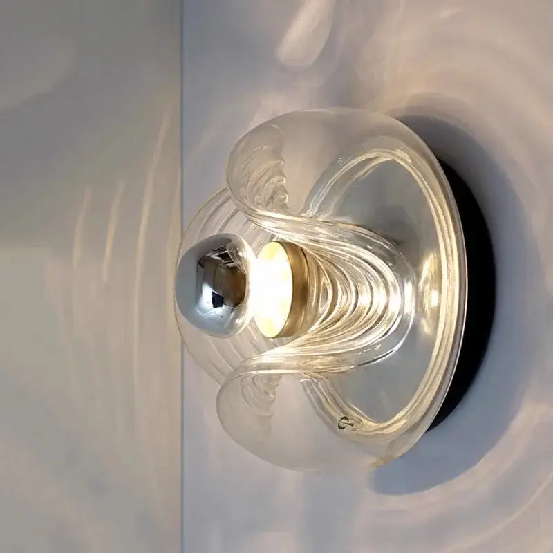 Modern circular swirling designer glass wall lamp with clear glass sconce and polished chrome accent for bedroom decorbites designer glass wall lamp