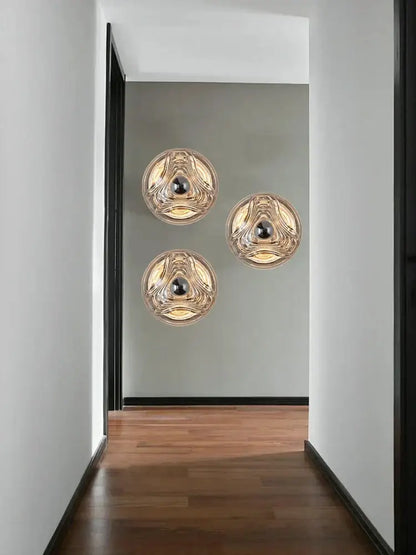 Modern circular swirling designer glass wall lamp with gold accents and black bulbs for bedroom decorbites designer glass