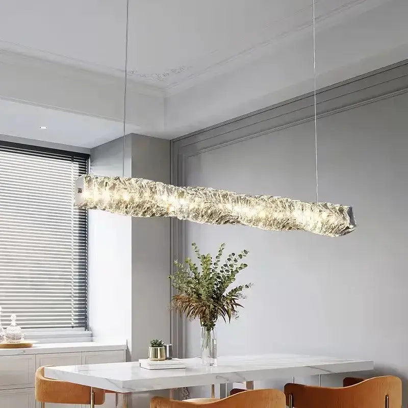 A modern circular textured crystal chandelier pendant light with a translucent glass body emitting warm illumination
