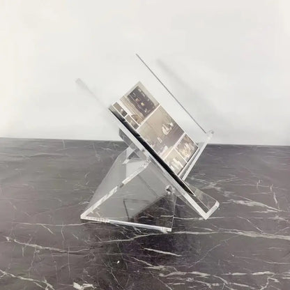 Modern clear acrylic geometric magazine rack holding a black-and-white brochure for office desktop storage