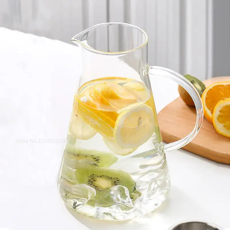Modern clear borosilicate glass pitcher with stainless steel lid filled with ice lemon slices and kiwi rounds