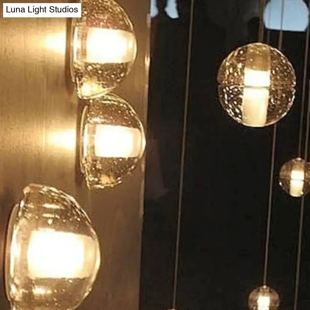 Modern clear bubble crystal wall light with textured glass globe and warm white interior illumination for living room