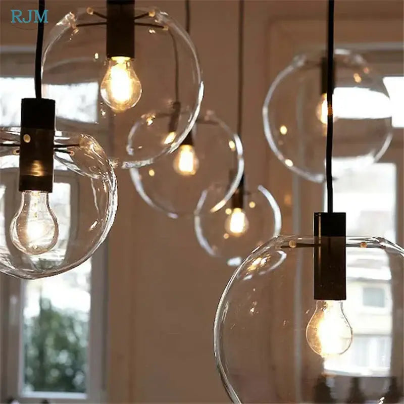 Modern clear bubble glass ball pendant light with black metal fixtures and exposed filament bulbs for kitchen decorbites pendant light