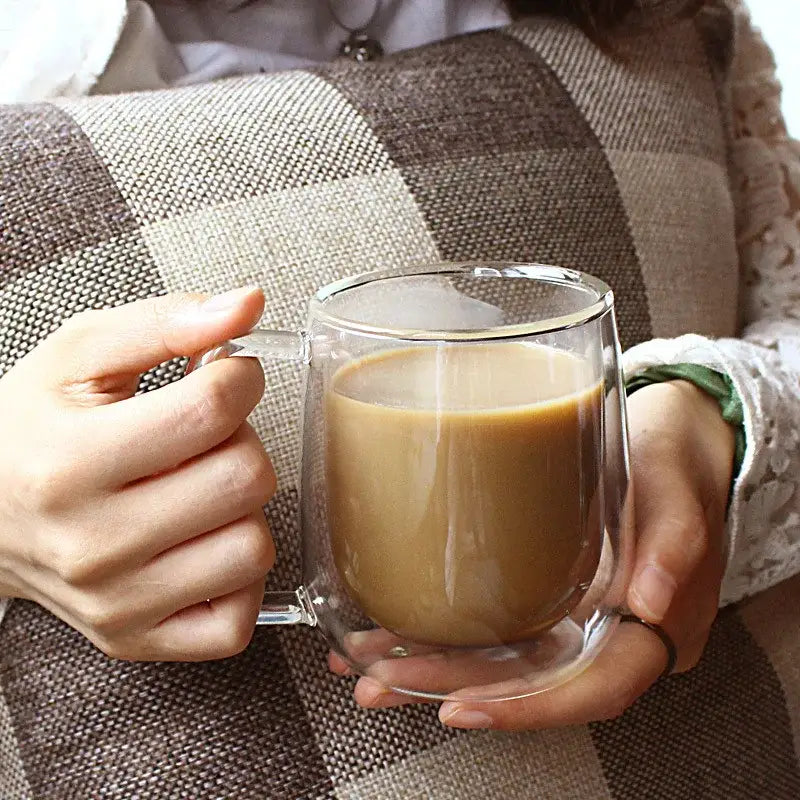 Clear modern double wall borosilicate glass mug with handle filled with coffee for kitchen use