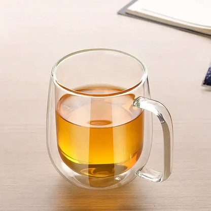 Modern clear double wall glass mug filled with amber tea showcasing the double wall glass design for kitchen use