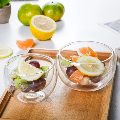Modern clear double wall glass salad bowl containing colorful fruit slices and grapes for kitchen use