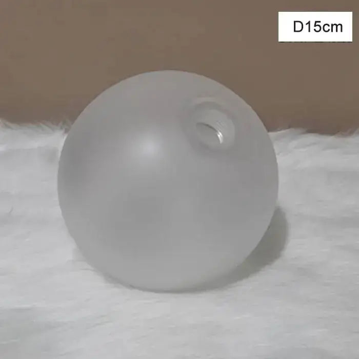 A frosted glass shade cover replacement with a smooth opaque surface and circular opening for living room use