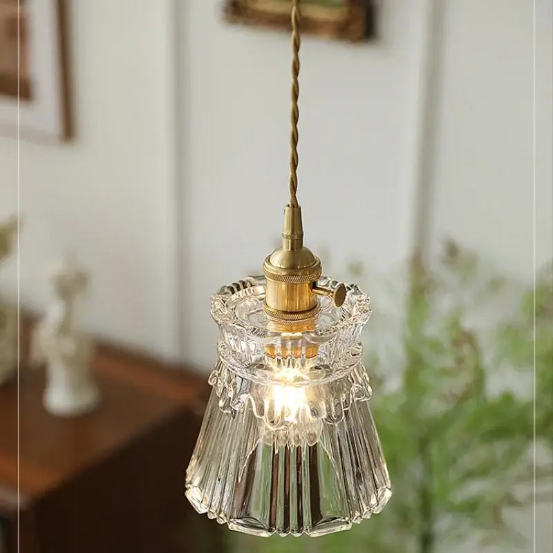 Modern clear glass copper pendant light featuring a clear glass shade with brass-finished socket and twisted cord decorbites pendant light