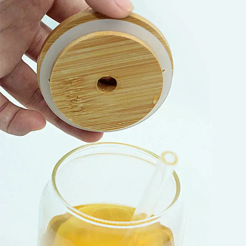 Modern clear glass cup with bamboo lid featuring a white silicone ring and central hole for decorbites glass cup