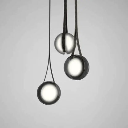 Modern clear glass designer pendant lights featuring sleek black spherical design and soft glowing illumination for bedroom decorbites designer pendant lights